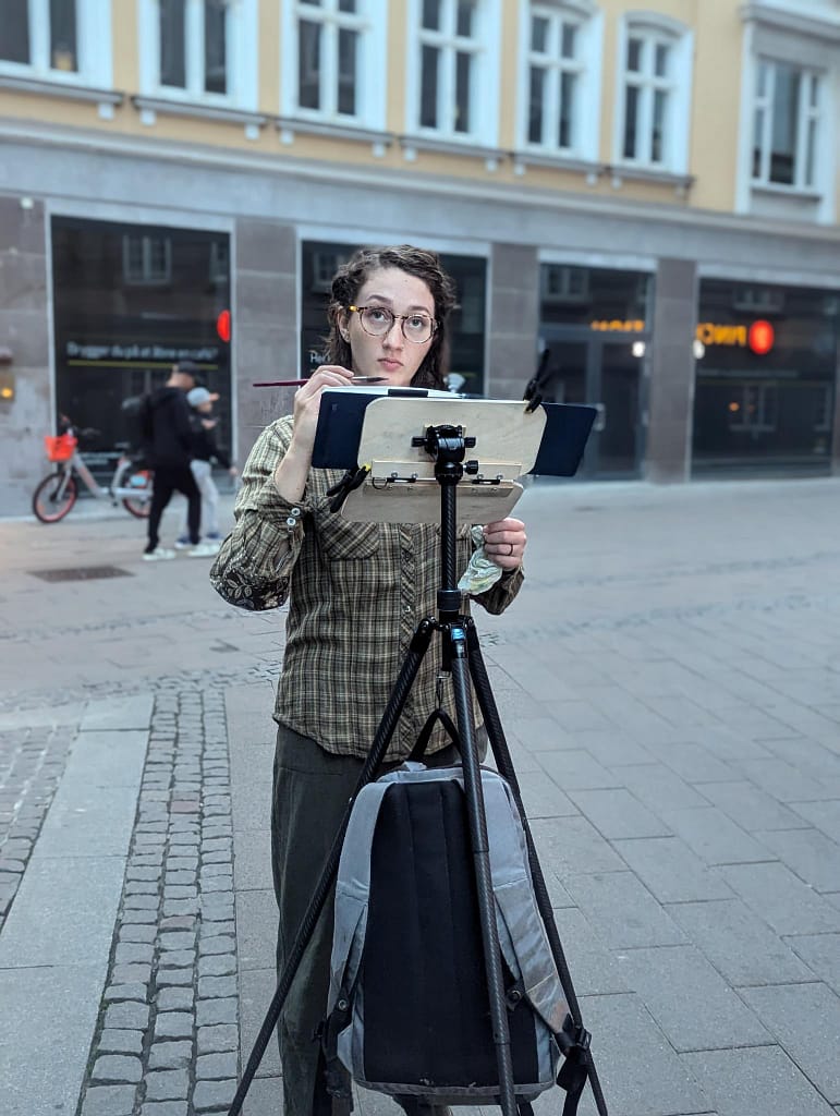 Photo of Mackenzie urban sketching using a Gurney-style easel.